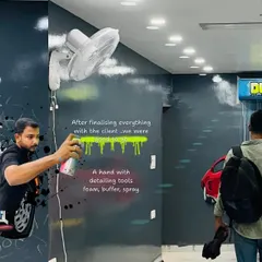 This image captures a moment during the final stages of the detailing studio project. The design incorporates tools of the trade like foam and spray buffers into the artwork itself.