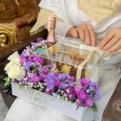 Unboxing the experience. This hamper is being prepared for a celebration, showcasing the clear acrylic box that protects and displays the beautiful arrangement inside.