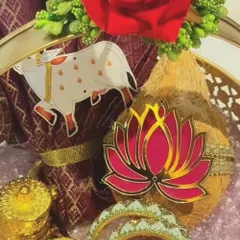 A detailed close-up of the traditional items within the brass basket. You can see the texture of the decorated coconut, the shimmer on the bangles, and the fine details on the sacred cow and lotus acrylic cutouts I use for decoration.