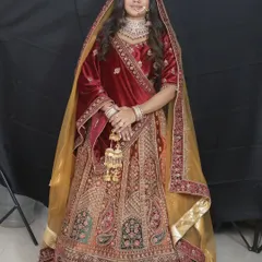 This maroon velvet lehenga is a favorite for winter weddings. The gold embroidery and matching kalire give it a truly royal feel.
