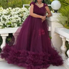 This beautiful wine-colored gown features a detachable bottom tail with dense ruffles, allowing you to switch from a grand look to a more comfortable one.