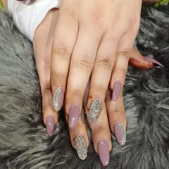 A statement look combining dusty rose polish with accent nails fully covered in chunky silver glitter and crystals.