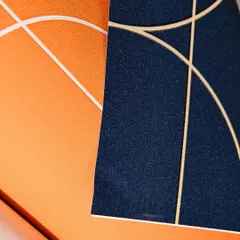 Dare to be bold with color. This image shows two vibrant wallpapers, a textured orange and a deep navy blue, both featuring clean, modern lines. These are perfect for creating an energetic and stylish space.