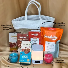 A beautiful blend of treats and tech in a reusable jute and cotton basket. This hamper contains a desk lamp with a clock, iris candles, and a variety of snacks like almond brittle, cookies, and quinoa puffs.