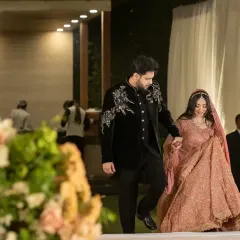 The groom gently guiding his bride into their reception. This candid shot captures a simple, loving gesture amidst the grandeur of the event.