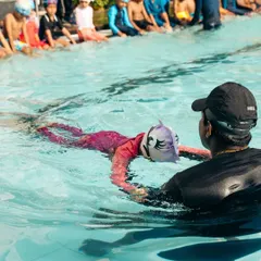 Personal attention is key to building confidence. Here, one of our coaches provides one-on-one guidance, helping a young swimmer perfect her floating technique in a group setting.