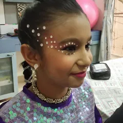A side view of the dance makeup, showing how the crystals are placed to catch the light as she moves. The hairstyle is a neat, braided ponytail to keep hair off her face.