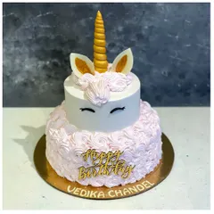 A beautiful two-tiered unicorn cake featuring delicate pink rosettes and a golden horn. This is one of our most popular designs for unicorn-themed birthday parties.