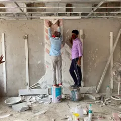 Here, skilled artisans are meticulously placing pieces of a marble inlay pattern on a wall. This behind-the-scenes shot captures the craftsmanship and attention to detail that goes into executing our complex and bespoke design elements on site.