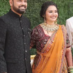 The perfect pair. Her traditional orange and maroon bridal look, complete with heavy gold jewellery, is balanced with soft, elegant makeup that enhances her natural features.