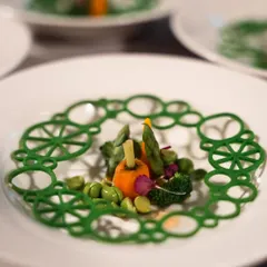 A dish inspired by the gardens of Versailles. We created an intricate, edible green lattice to frame a selection of fresh garden vegetables, evoking the formal patterns of the palace's famous landscapes.