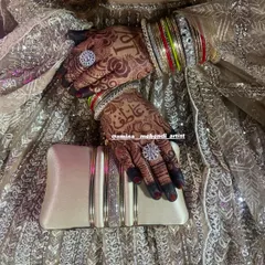 A beautiful shot of the bride's hands with her rings and clutch, showing how the mehendi complements her entire look.