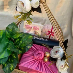 A heartfelt goodbye hamper for a senior. This gift features a Furoshiki-wrapped present, a personalized jewelry organizer, and white flowers, all arranged in a golden metal basket.