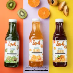 This image uses color-blocking to showcase a range of fruit juices. The distinct colored backgrounds for each bottle create a visually striking and organized product lineup, perfect for a catalogue or website.