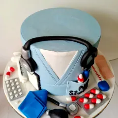 An overhead view of the doctor-themed cake, showing the stethoscope resting on the fondant scrubs. I made sure every element was clean and precise to honor the dedication of healthcare workers.
