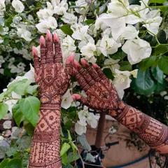 Here, the focus is on the detailed grid and checkerboard patterns, known as jaali, which add depth and complexity to this full-arm festive henna design.