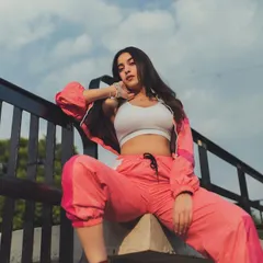 A shot from a photoshoot where I styled a sporty, athleisure look. This pink and white tracksuit paired with a simple white crop top creates a modern, confident, and relaxed vibe.