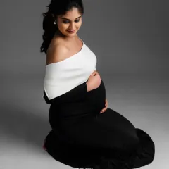 A graceful kneeling pose in a black gown, demonstrating how to create elegant lines and highlight the bump.