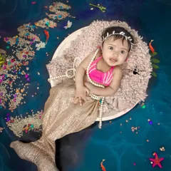 An adorable mermaid resting in her seashell. The shimmering tail, pearl necklace, and underwater effects create a beautiful fantasy scene.