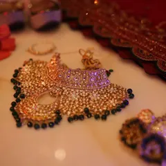 A flat-lay shot of the bride's stunning wedding jewelry set, including the necklace, earrings, and nath, ready for her big day.