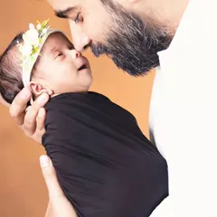 A father holding his newborn daughter close, a powerful portrait that freezes a moment of pure love. We encourage parents to be part of the newborn session.