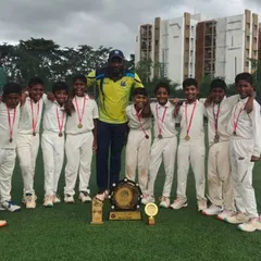 Our victorious U-10 team with their coach, proudly displaying their medals and the championship shield after a successful summer camp tournament.