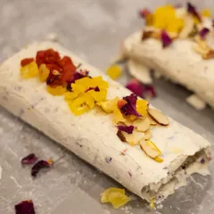 A pristine shot of our Mishti Malai, showcasing the delicate roll and colourful toppings. This signature dessert is a modern twist on traditional Indian flavours.