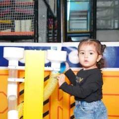 Our toddler area is full of engaging activities. Here, a little one discovers a fun, interactive wall feature designed for sensory play.
