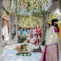A bride awaits the start of her ceremony in our 'Love in Ruins' mandap. The design, featuring ancient-style stone pillars and organic floral growth, was created to feel timeless and seamlessly integrated with the venue's natural beauty.
