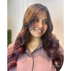 Our happy client showing off her new balayage, with face-framing layers and a beautiful blend of natural and red tones.
