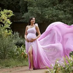 A fairytale moment in nature. The vibrant pink of this flowing gown creates a beautiful contrast with the lush greenery of the park, making for a magical outdoor portrait.