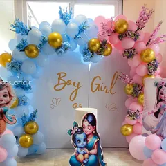 A creative 'Boy or Girl' gender reveal setup with a Krishna and Radha theme. The decor is split into blue and pink sections with matching balloon arches, character cutouts, and floral accents.