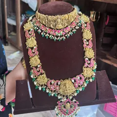 A beautiful temple jewellery set on display. The choker and long haram both feature intricate goddess motifs and are studded with kemp stones.