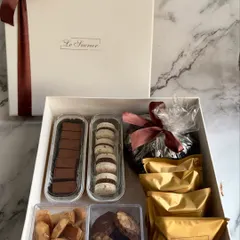 My large Diwali assortment hamper is designed for generous gifting. It contains a wide variety of treats, including chocolate fudge, marble cookies, a mini tea cake, and individually packed brownies.