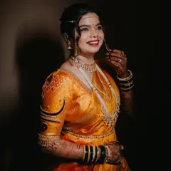 The complete look for this beautiful Maharashtrian bride. Dressed in a traditional yellow Paithani saree, her makeup is subtle yet defining, with a focus on her expressive eyes.