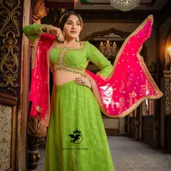 A stunning studio shot of the lime green and pink lehenga worn by Nishvika. The flying dupatta adds a touch of drama and showcases the beautiful bandhani print.