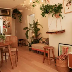 Even a small apartment can feel like a lush retreat. We use a mix of floor plants, hanging vines, and tabletop greenery to maximize the green footprint, turning this living area into a cozy, bohemian jungle.