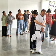A key part of our training is learning to escape common holds. This image shows a student at our LSR College workshop practicing a technique to break free from a rear grab, a crucial skill for personal safety.