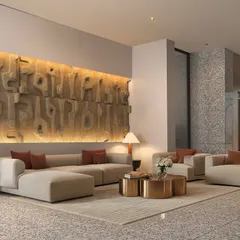 This lounge area within the Gulnaar Zenium project serves as a welcoming space for residents and guests. The design features a custom, back-lit art wall, plush seating, and metallic accents to create a comfortable yet highly sophisticated atmosphere.