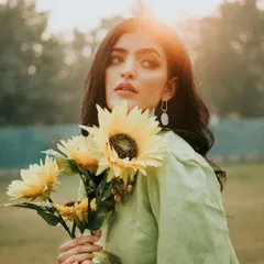 Capturing the soft, warm glow of the golden hour. This natural light portrait uses the setting sun as a beautiful backlight, creating a dreamy, story-driven image with a vintage feel in an open park setting.