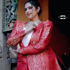 A closer look at the red brocade pantsuit, showing the rich texture of the fabric and the sharp cut of the lapels. I paired it with a simple white top to let the suit be the star of the outfit.