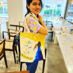 A participant from my tote bag painting workshop proudly displaying her musical-themed creation. These sessions are great for private groups and corporate events.