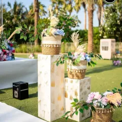 Small details make a big impact. These floral arrangements on modern white pedestals add a touch of elegance to an outdoor wedding walkway.