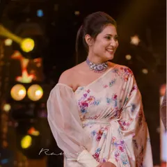Actress Amrutha Iyengar looking stunning in our bespoke floral satin saree. The modern off-shoulder blouse with a single voluminous tulle sleeve creates a high-fashion, red-carpet-ready look.