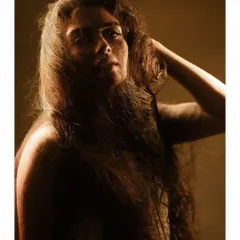 The same concept, but with a slightly different angle. The play of light and shadow across the face and hair creates a sense of mystery and drama.