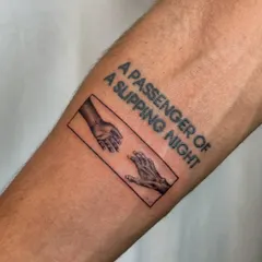 A memorial tattoo that tells a story of love and loss. It features the iconic "Creation of Adam" hands, symbolizing a connection that transcends the physical, with the poignant phrase "A passenger of a slipping night."