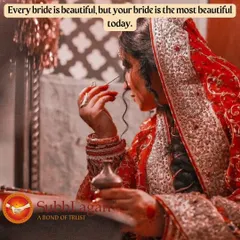 A bride in a traditional red saree applies kohl to her eyes, a final touch before the ceremony. We appreciate the care and tradition that go into a bride's preparation.