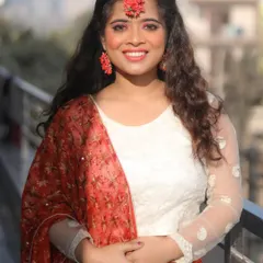 A fresh and radiant Haldi ceremony look. The makeup is light and dewy to give a natural glow, complemented by beautiful floral jewelry and a bright, happy smile.