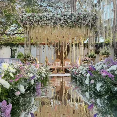 A modern fairy tale comes to life. This mandap combines a reflective mirror aisle with a cascade of lilac and white florals, creating a breathtaking space for you to say your vows.