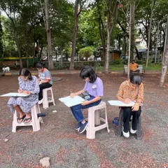 Our students set up in a local park, fully concentrated on their sketchpads. These sessions are designed to build their confidence in drawing in a public setting.